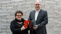 Zwei Personen präsentieren ein kreatives Kunstwerk