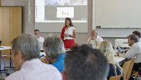 Präsentation in einem modernen Konferenzraum mit virtueller Teilnahme