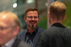 L&auml;chelnder Mann im Gespr&auml;ch mit einem Freund