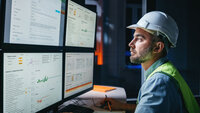 Ingenieur analysiert Daten auf mehreren Bildschirmen