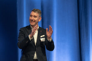 Ein begeisterter Redner auf der B&uuml;hne w&auml;hrend einer Konferenz