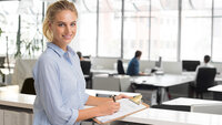 Junge Frau in modernem Büro mit Notizblock