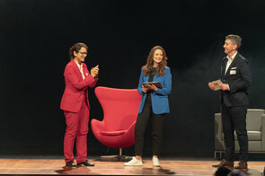 Drei Moderatoren auf der B&uuml;hne bei einer Veranstaltung