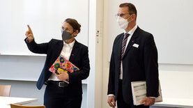 Zwei Personen in einem Besprechungsraum mit Masken