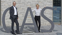 Zwei Personen posieren mit großen Buchstaben CAS