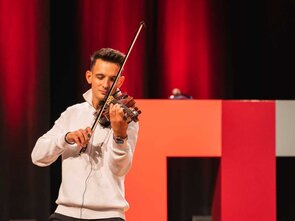 Junger Mann spielt Geige auf der B&uuml;hne