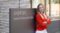 Junge Frau vor Eingang DHBW CAS