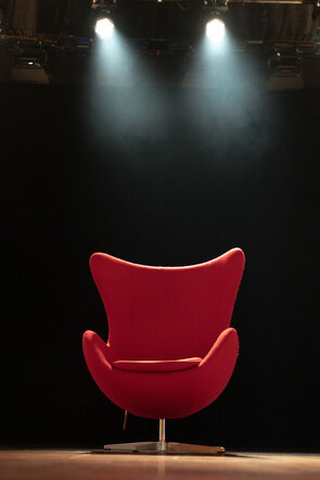 Roter Sessel im Scheinwerferlicht auf der B&uuml;hne