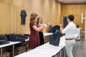 Freundliche Interaktion w&auml;hrend der T-Shirt-&Uuml;bergabe im B&uuml;ro